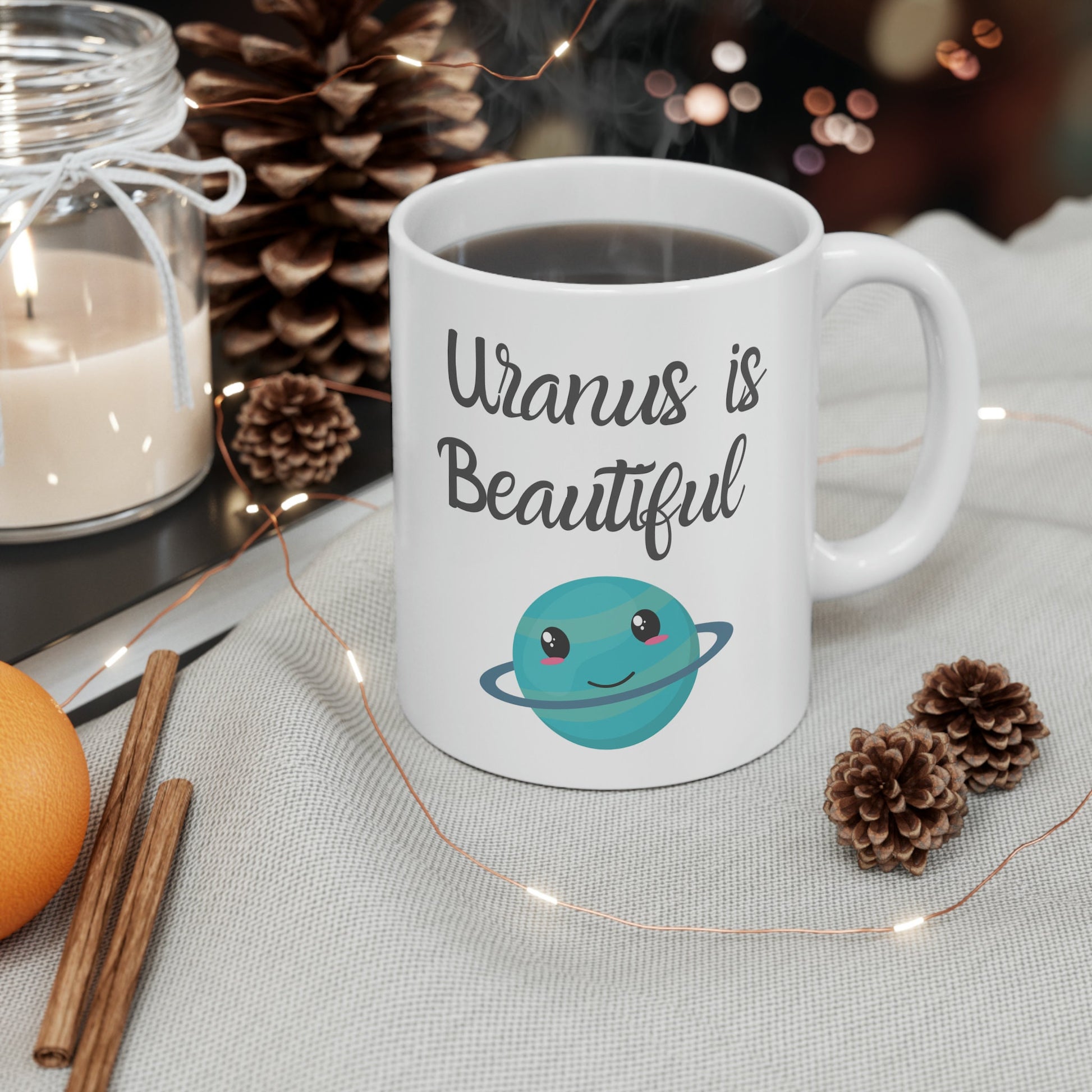 White Ceramic Mug with words in Script style black font that say, Uranus is Beautiful.  Beneath you find a Cute graphic of the Planet Uranus with an adorable face.  Check out the shop for more items at www.scorpiontees.etsy.com