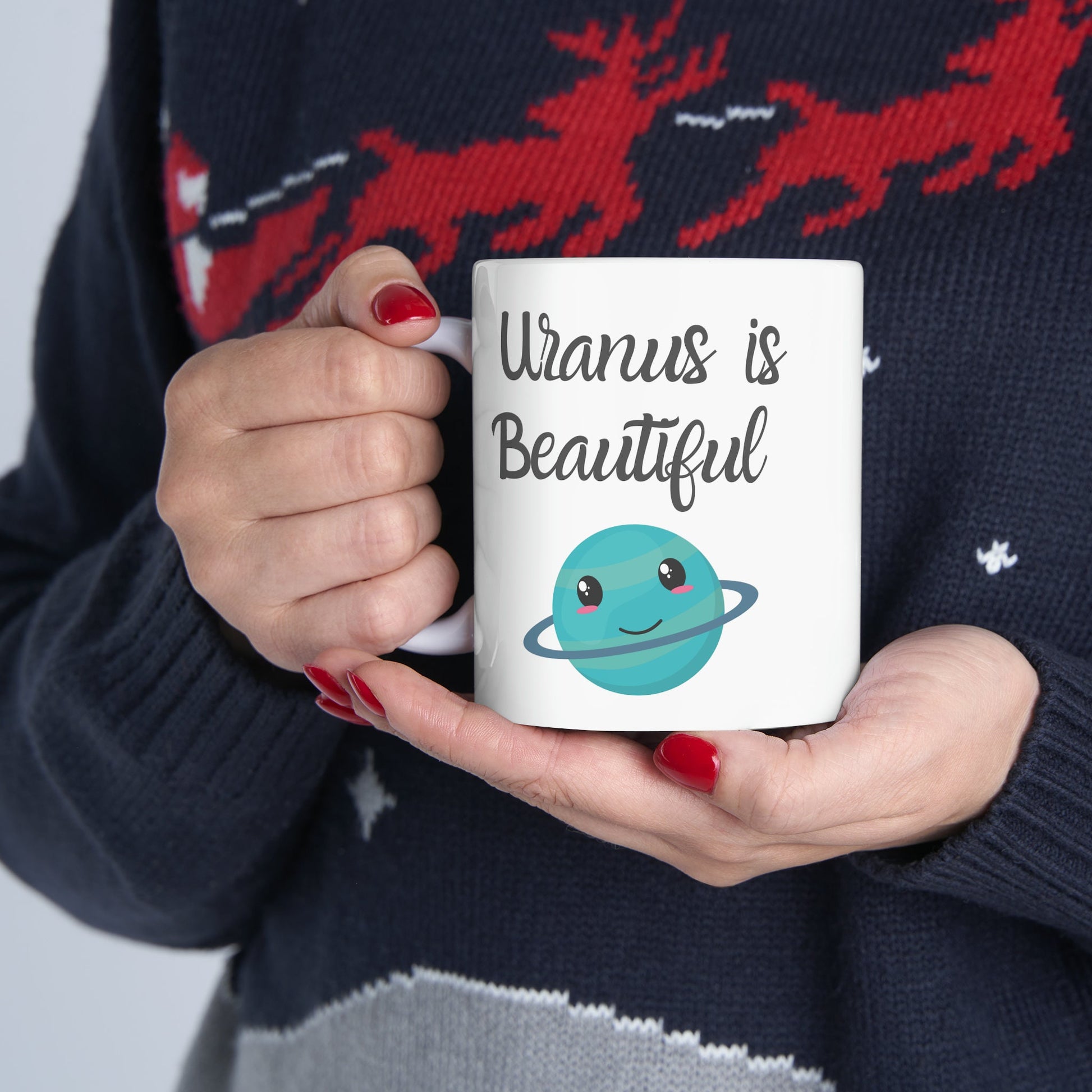 White Ceramic Mug with words in Script style black font that say, Uranus is Beautiful.  Beneath you find a Cute graphic of the Planet Uranus with an adorable face.  Check out the shop for more items at www.scorpiontees.etsy.com