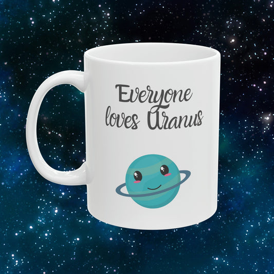 White Ceramic Mug with words in Script style black font that say, Everyone Loves Uranus. Beneath you find a Cute graphic of the Planet Uranus with an adorable face.  Check out the shop for more items at www.scorpiontees.etsy.com