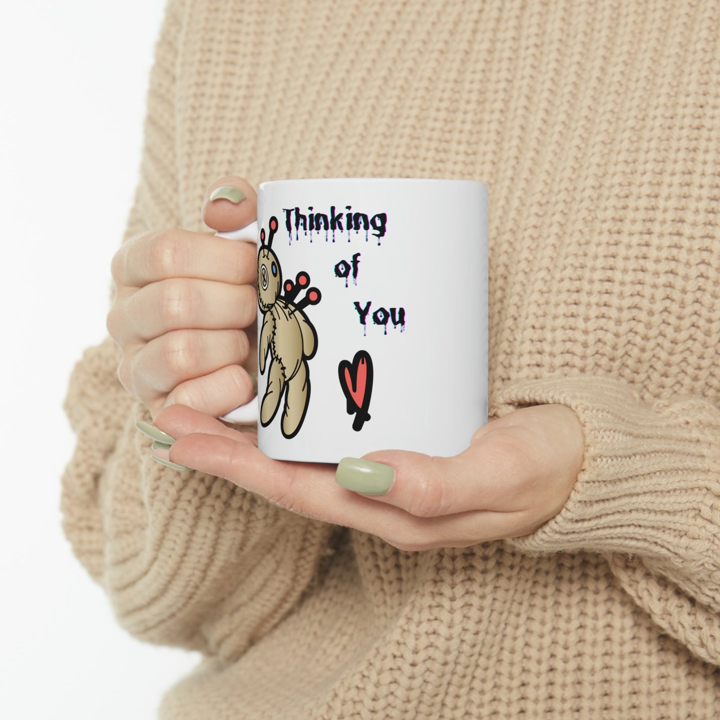 white ceramic coffee mug with a Voo doo doll being poked with pins.  The words Thinking of you are written in a scary dripping Halloween Font.  A red heart is under the wording.  Check out my shop at www.scorpiontees.etsy.com