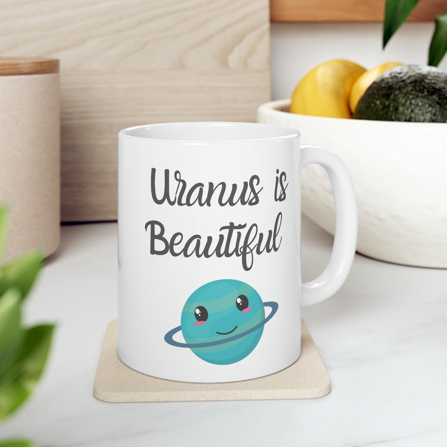 White Ceramic Mug with words in Script style black font that say, Uranus is Beautiful.  Beneath you find a Cute graphic of the Planet Uranus with an adorable face.  Check out the shop for more items at www.scorpiontees.etsy.com