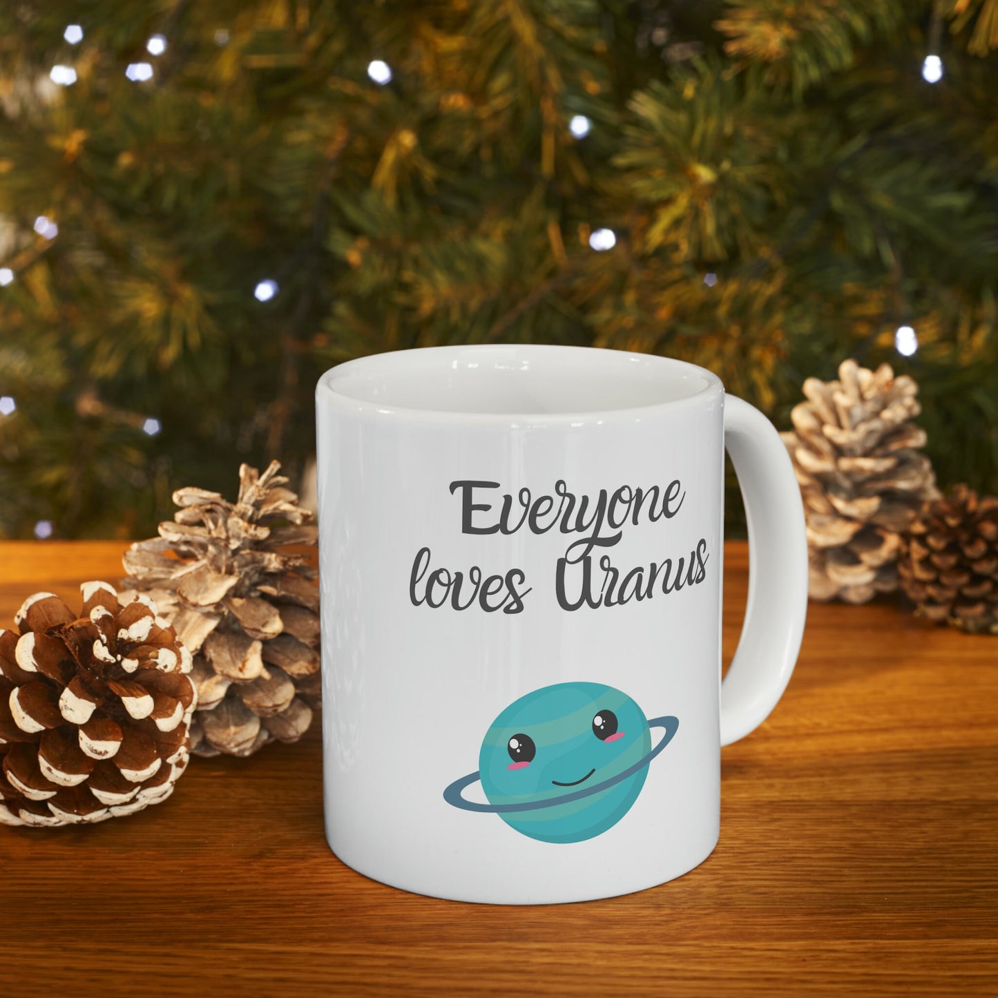 White Ceramic Mug with words in Script style black font that say, Everyone Loves Uranus. Beneath you find a Cute graphic of the Planet Uranus with an adorable face.  Check out the shop for more items at www.scorpiontees.etsy.com
