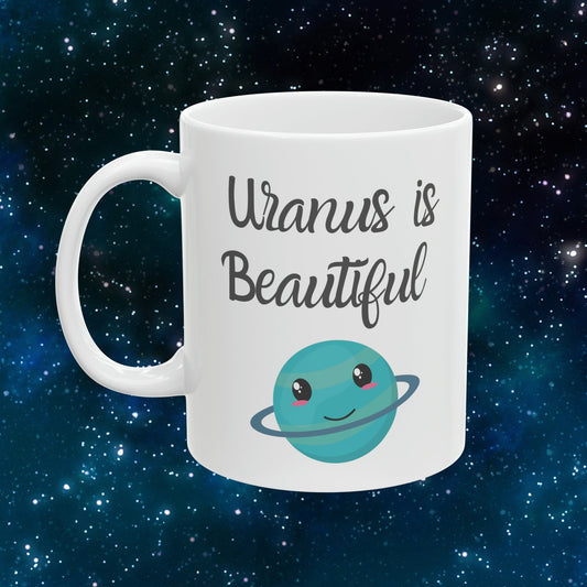 White Ceramic Mug with words in Script style black font that say, Uranus is Beautiful.  Beneath you find a Cute graphic of the Planet Uranus with an adorable face.  Check out the shop for more items at www.scorpiontees.etsy.com